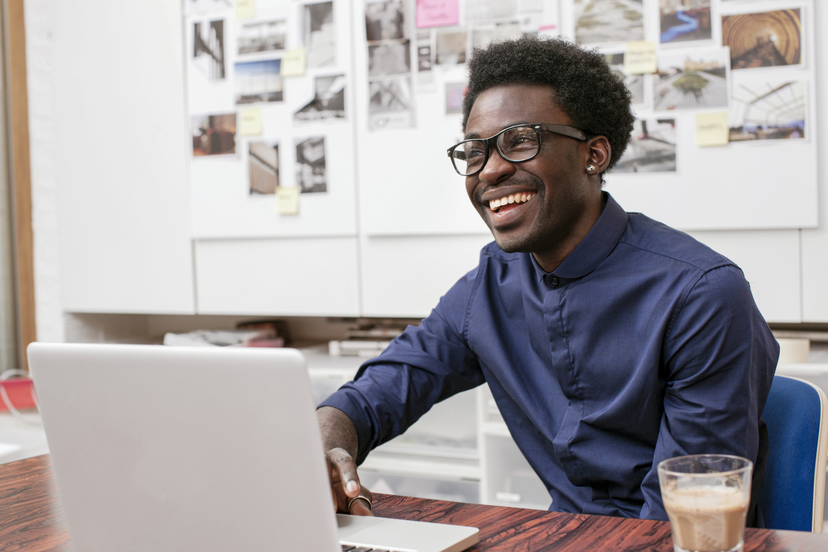 Man smiling in front of a laptop